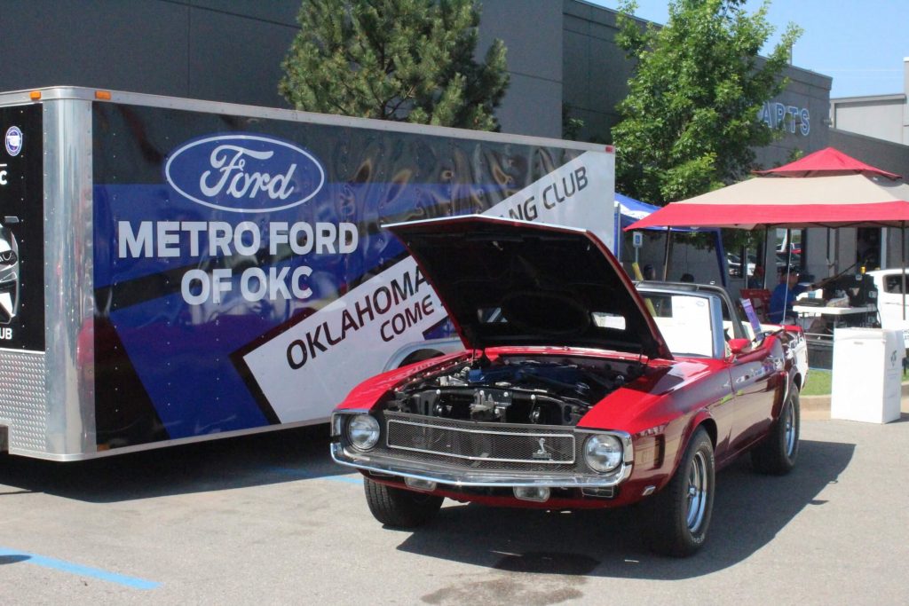 A Ford mustang in front of a Metro Ford OKC Trailer