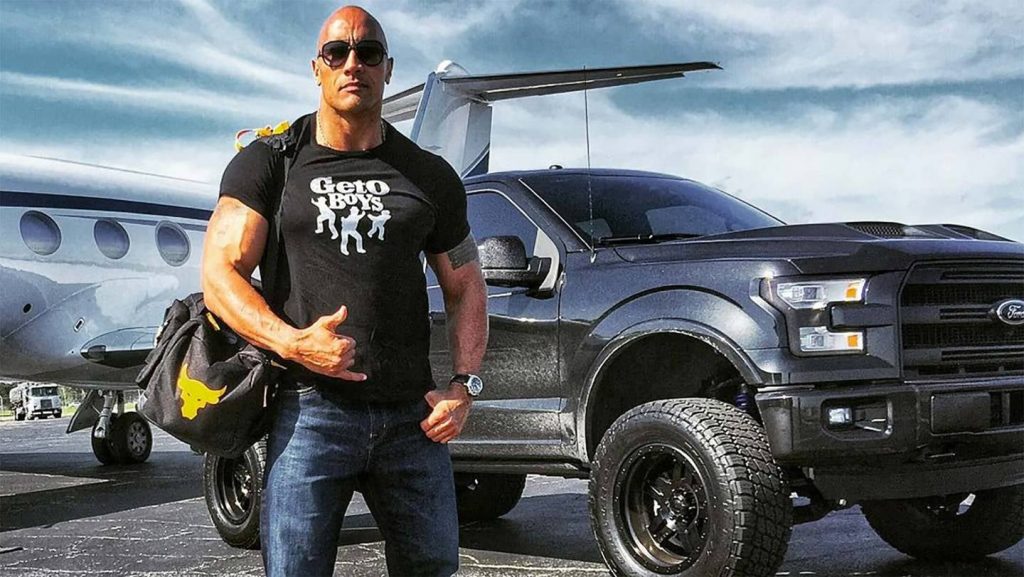 The Rock standing in front of a Ford F-150